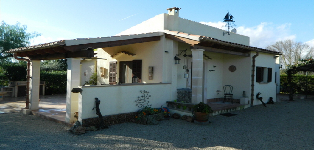 Die Finca Caseta Magdalena mit überdachter Terrasse unter blauem Himmel