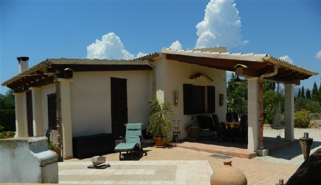 Haupthaus der Finca mit überdachter Terrasse und Liegestuhl